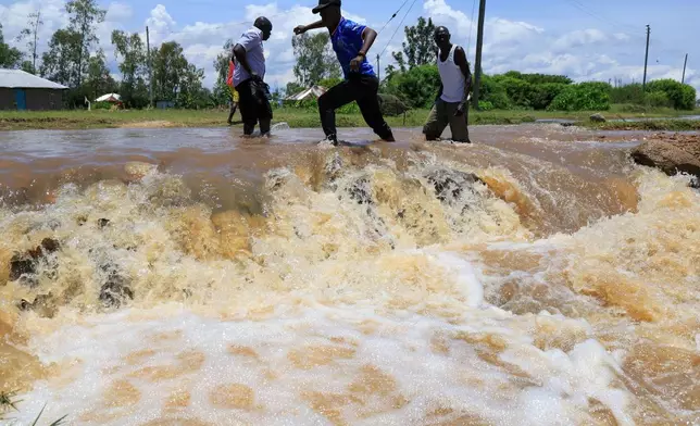 人們周二（2026年3月24日）在肯尼亞西部尼亞卡奇（Nyakach）涉水穿過被洪水淹沒的道路。（美聯社圖片/Andrew Kasuku） AP圖片