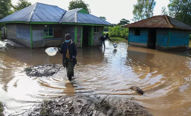 一名女子周二（2026年3月24日）在肯尼亞西部阿希羅（Ahero）的洪水中行走。（美聯社圖片/Andrew Kasuku） AP圖片