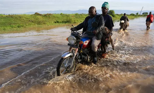 人們周二（2026年3月24日）在肯尼亞西部阿希羅（Ahero）的洪水中騎行。（美聯社圖片/Andrew Kasuku） AP圖片