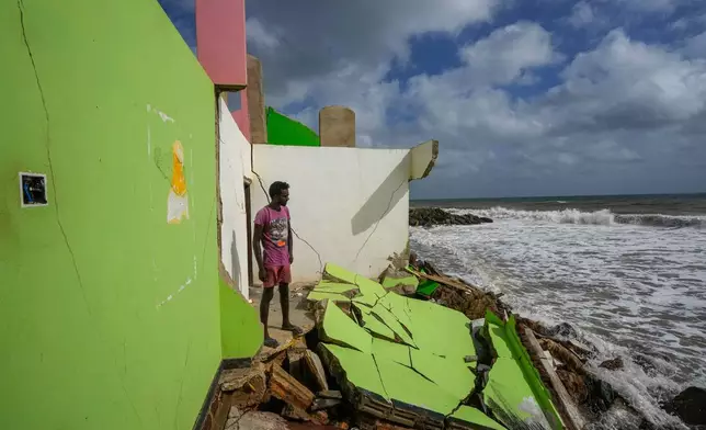 攝於2023年6月15日，斯里蘭卡伊拉納維拉，迪爾魯克山·庫馬拉（Dilrukshan Kumara）站在家人房屋的殘骸旁望向大海。 AP圖片