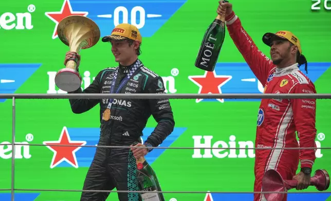 平治車手堅尼安東尼利（Andrea Kimi Antonelli）（左）在中國上海國際賽車場舉行的中國一級方程式大獎賽後，與獲得第三名的法拉利車手咸美頓（Lewis Hamilton）一同在頒獎台上慶祝，攝於周日（2026年3月15日）。（美聯社圖片/Andy Wong） AP圖片