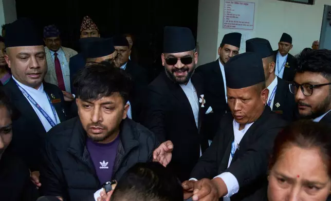 2026年3月26日周四，戴著太陽眼鏡的巴連德拉沙（中）抵達尼泊爾加德滿都的聯邦議會，出席新當選眾議院議員的宣誓就職儀式。(美聯社圖片/Niranjan Shrestha) AP圖片