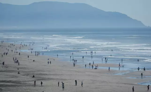 2026年3月17日周二，人們到訪三藩市海洋灘。(美聯社圖片/Jeff Chiu) AP圖片