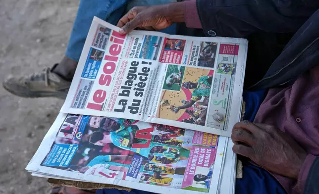 (美聯社圖片/Misper Apawu) 2026年3月18日周三，塞內加爾達喀爾的民眾閱讀報章，內容關於非洲足協決定褫奪塞內加爾國家足球隊的非洲國家盃冠軍，並將其授予摩洛哥國家足球隊。 AP圖片