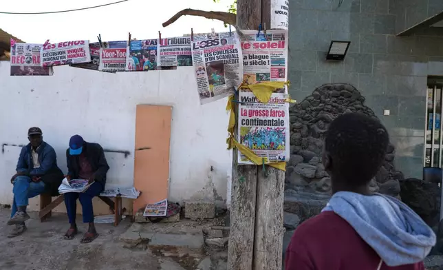 (美聯社圖片/Misper Apawu) 2026年3月18日周三，塞內加爾達喀爾的民眾閱讀報章，內容關於非洲足協決定褫奪塞內加爾國家足球隊的非洲國家盃冠軍，並將其授予摩洛哥國家足球隊。 AP圖片
