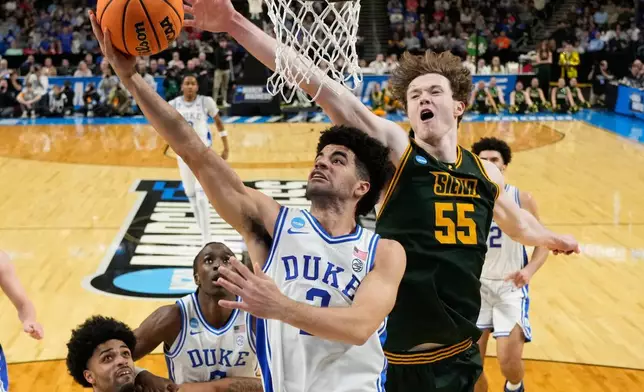 2026年3月19日周四，在南卡羅來納州格林維爾舉行的NCAA大學籃球錦標賽首圈賽事中，杜克大學後衛凱登布澤在下半場運球突破錫耶納中鋒萊利馬爾維。（美聯社圖片/Chris Carlson） AP圖片