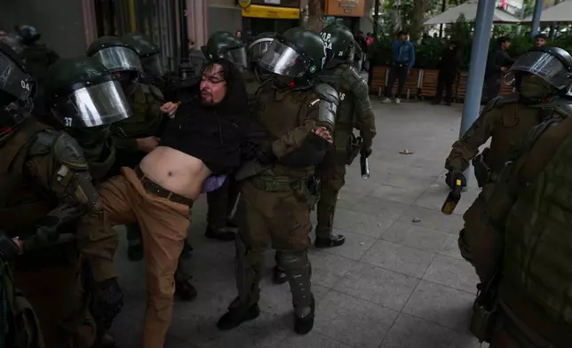 周日（2026年3月22日），防暴警察在智利聖地亞哥一場世界水日遊行中拘捕一名示威者，該遊行要求加強環境保護及動物福利。(美聯社圖片/Esteban Felix) AP圖片