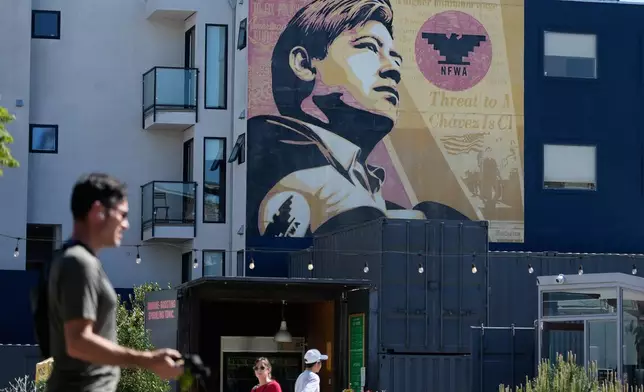 2026年3月18日周三，行人從三藩市（San Francisco）一幅壁畫上施薩查韋斯（César Chavez）的圖像下方走過。(美聯社圖片/Jeff Chiu) AP圖片