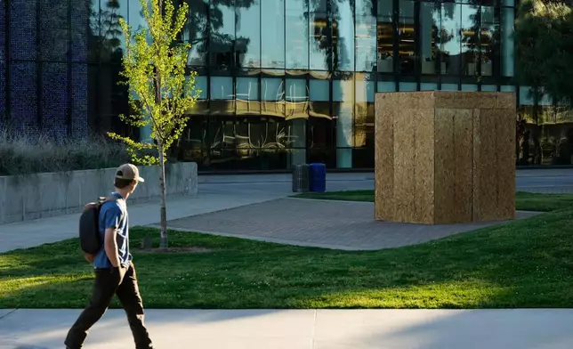 2026年3月18日周三，加州弗雷斯諾（Fresno, Calif.），加州州立大學弗雷斯諾分校（California State University, Fresno）一名學生望向覆蓋著塞薩爾查韋斯（César Chavez）雕像的木箱。（美聯社圖片/Godofredo A. Vásquez） AP圖片