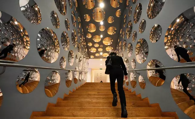 一名女子在2026年3月12日周四於科隆路德維希博物館舉行的草間彌生大型展覽預展中，走過藝術裝置《隱形生活》（Invisible Life）。(AP Photo/Martin Meissner) AP圖片