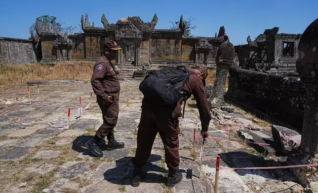 柬埔寨排雷行動中心（CMAC）一名排雷人員在柏威夏寺一條在與泰國邊境衝突中受損的小徑上進行安全檢查。 AP圖片