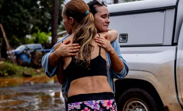 2026年3月21日周六，夏威夷哈雷瓦（Haleiwa）一場迅速蔓延的洪水損毀了大部分社區，翌日，琳達·格里菲斯（Linda Griffith）（左）擁抱鄰居法蘭基（Frankie）。(Stephen Lam/三藩市紀事報 via 美聯社圖片) AP圖片