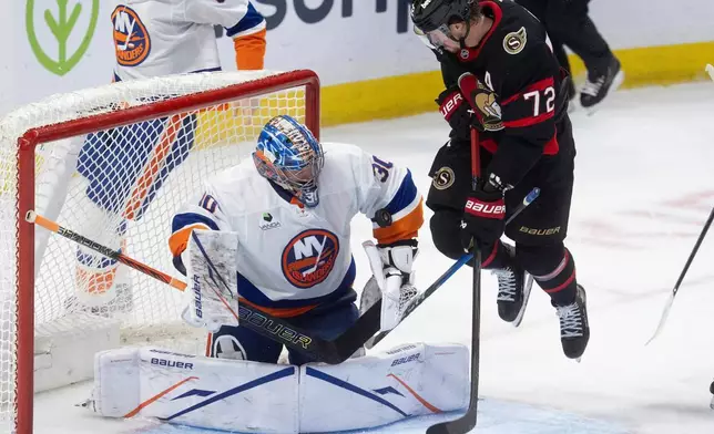 紐約島人隊門將伊利亞索羅金（Ilya Sorokin，30號）在第三節國家冰球聯盟賽事中作出撲救，渥太華參議員隊球員湯馬士查博（Thomas Chabot，72號）在其前方阻擋視線。攝於2026年3月19日周四，加拿大渥太華。(Adrian Wyld/The Canadian Press via AP) AP圖片