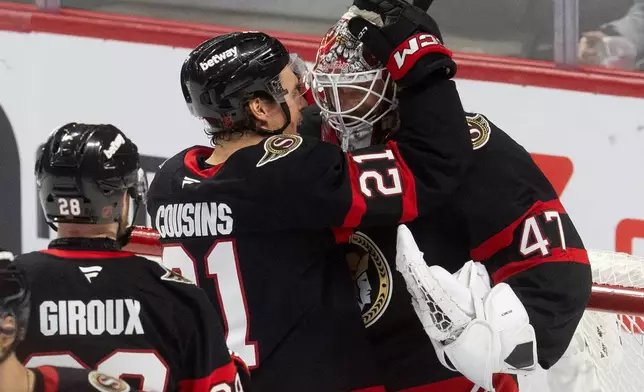 渥太華參議員隊球員尼克卡辛斯（Nick Cousins，21號）在擊敗紐約島人隊的國家冰球聯盟賽事後，向門將占士賴默（James Reimer，47號）表示祝賀，克勞德吉魯（Claude Giroux，28號）在旁觀看。攝於2026年3月19日周四，加拿大安大略省渥太華。(Adrian Wyld/The Canadian Press via AP) AP圖片