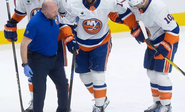 紐約島人隊球員安東尼杜克萊爾（Anthony Duclair，中）在第二節對陣渥太華參議員隊的國家冰球聯盟賽事中，因擋下射門後受傷，在隊友協助下離場。攝於2026年3月19日周四，加拿大安大略省渥太華。(Adrian Wyld/The Canadian Press via AP) AP圖片