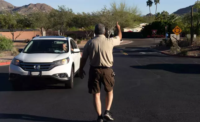 2026年3月19日周四，鳳凰城駱駝背山，鳳凰城市公園管理員Sam Weller引導遠足人士離開因極端高溫而關閉的步道起點。(美聯社圖片/Rebecca Noble) AP圖片