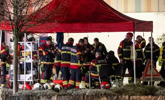 周二（2026年3月10日），瑞士凱策斯一輛郵政巴士起火釀成多人死傷，消防員在燒至剩下支架的巴士旁集結。(Alessandro della Valle/Keystone via AP) AP圖片