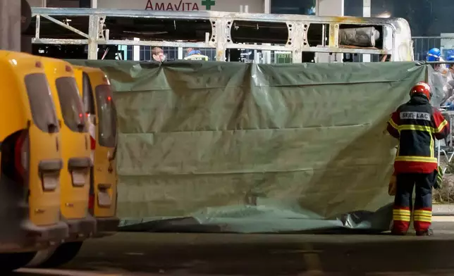 周二（2026年3月10日），瑞士凱策斯一輛郵政巴士起火造成多名乘客傷亡，消防員及警員在現場設置圍欄封鎖區域。(Laurent Merlet/Keystone via AP) AP圖片