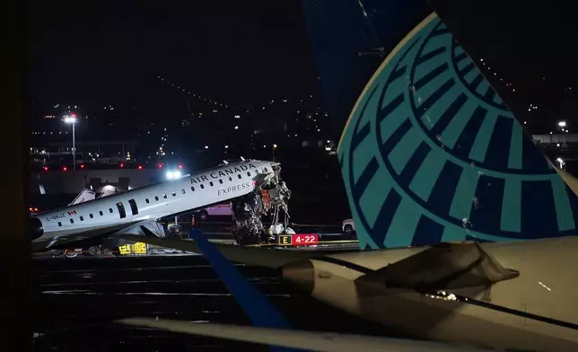 一架加拿大航空客機周一（2026年3月23日）在紐約拉瓜迪亞機場降落後，與一輛港務局飛機救援及消防車相撞，其後停泊在跑道上。(美聯社圖片/Ryan Murphy) AP圖片