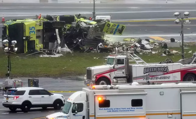 一輛港務局（Port Authority）消防車在紐約拉瓜迪亞機場跑道旁側翻，事發於2026年3月23日周一，此前一架加拿大航空客機於周日深夜降落後不久與其相撞。(美聯社圖片/Seth Wenig) AP圖片