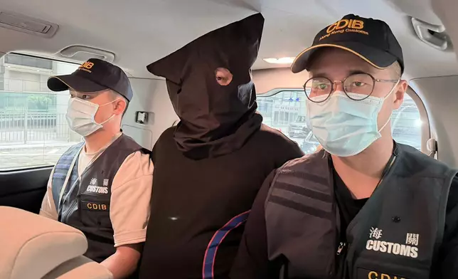 首宗案件中的被捕人士（中）。 政府新聞處圖片