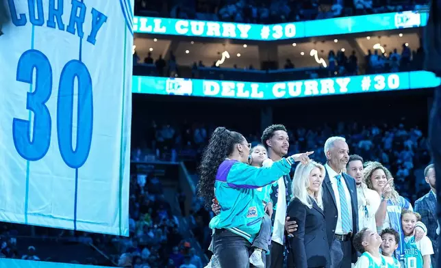 前夏洛特黃蜂球員戴爾居里（左五），周四（2026年3月19日）在北卡羅來納州夏洛特對陣奧蘭多魔術的NBA籃球賽中場休息時，其球衣退役儀式上與家人合影。(美聯社圖片/Matt Kelley) AP圖片