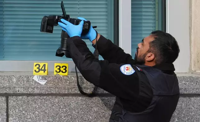 多倫多警方鑑證人員在美國領事館門前拍攝彈孔痕跡。AP圖片