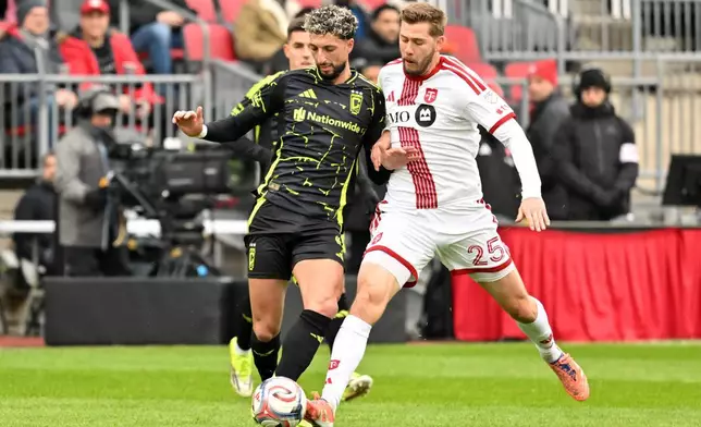 哥倫布機員前鋒韋森艾布阿里（左），在2026年3月21日周六於多倫多舉行的一場美職聯賽事上半場，與多倫多FC後衛禾加辛曼爭奪皮球。 (Jon Blacker/The Canadian Press via AP) AP圖片