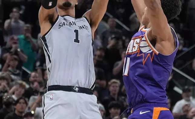 2026年3月19日，聖安東尼奧馬刺前鋒維克多·文班亞馬（Victor Wembanyama）（1號）在NBA籃球賽下半場最後幾秒，射入致勝一球，擊敗鳳凰城太陽前鋒奧素伊格達羅（Oso Ighodaro）（11號）。攝於聖安東尼奧。（美聯社圖片/Eric Gay） AP圖片