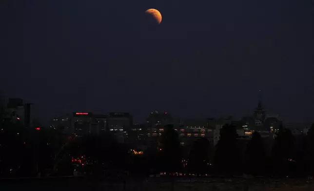 月全食前夕，月亮在北京辦公大樓上空可見。攝於2026年3月3日（星期二）。(美聯社圖片/Andy Wong) AP圖片