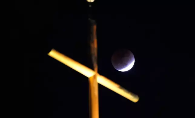 月全食在南韓首爾一間教堂的十字架後方可見。攝於2026年3月3日（星期二）。(美聯社圖片/Ahn Young-joon) AP圖片