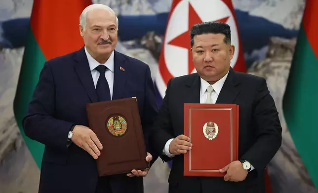 白俄羅斯總統新聞部門發布的圖片顯示，北韓領袖金正恩（右）與白俄羅斯總統盧卡申科於2026年3月26日周四，在北韓平壤會晤期間手持已簽署文件。(美聯社圖片/白俄羅斯總統新聞部門) AP圖片