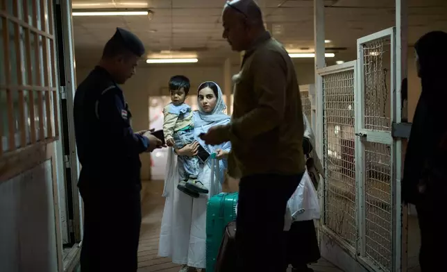 一名伊拉克邊境警員，在伊拉克巴士拉附近的沙拉姆切邊境口岸，檢查從伊朗入境人士的護照。攝於2026年3月29日周日。(美聯社圖片/Leo Correa) AP圖片