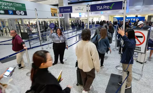 旅客周四（19日）在侯斯頓佐治布殊洲際機場被引導通過安檢隊伍。AP圖片