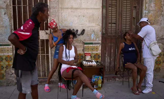 3月5日，古巴哈瓦那，停電期間髮型師在戶外為顧客理髮。AP圖片