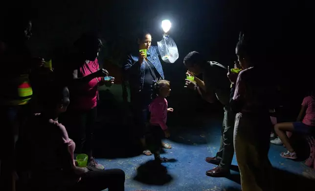 3月4日，哈瓦那，停電期間一名男子在街上餵一名女孩喝湯。AP圖片