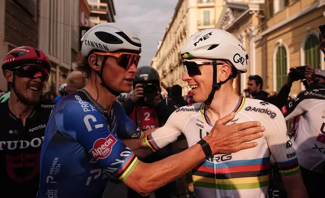 2026年3月21日，意大利帕維亞至聖雷莫的米蘭-聖雷莫單日單車精英賽（298公里）中，斯洛文尼亞車手普高查（右）在奪冠後，獲阿爾佩辛-普利美科技車隊（Alpecin-Premier Tech）的雲迪普爾祝賀。(Marco Alpozzi/LaPresse via AP) AP圖片