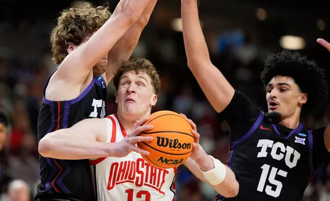 2026年3月19日周四，南卡羅來納州格林維爾，全國大學體育協會大學籃球錦標賽首圈上半場，俄亥俄州立大學中鋒基斯托夫蒂利（Christoph Tilly）在德州基督教大學後衛柳陶拉斯萊萊維修斯（Liutauras Lelevicius）及前鋒大衛龐治之間運球上籃。(美聯社圖片/Chris Carlson) AP圖片