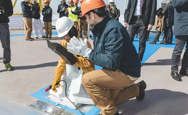 維京郵輪一位人工智能專家在下水儀式上，將儀式硬幣焊接到維京天秤號的桅杆上。 AP圖片