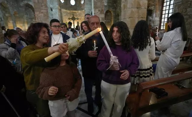 2026年3月29日周日，在黎巴嫩南部港口城市泰爾的聖湯瑪斯大教堂，信徒們點燃蠟燭，參與棕枝主日彌撒遊行。(美聯社圖片/Hussein Malla) AP圖片