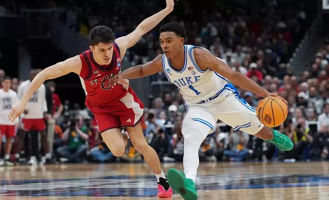 2026年3月27日周五，在華盛頓舉行的全美大學體育協會（NCAA）大學籃球錦標賽「甜蜜十六強」賽事中，杜克大學後衛迦勒科士打（1號）在下半場對陣聖約翰大學時，運球突破聖約翰大學後衛戴倫達寧（0號）。(美聯社圖片/Stephanie Scarbrough) AP圖片