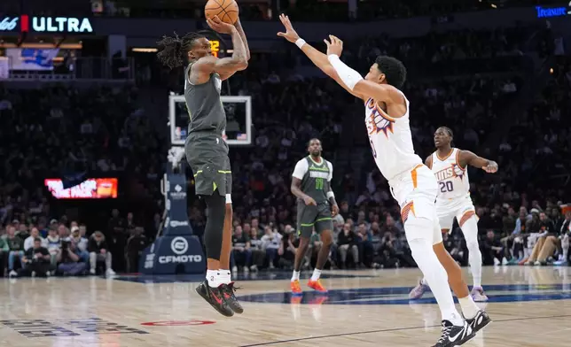 明尼蘇達木狼後衛邦斯海蘭（Bones Hyland）（左）在鳳凰城太陽前鋒賴恩鄧恩（Ryan Dunn）面前投籃。AP圖片