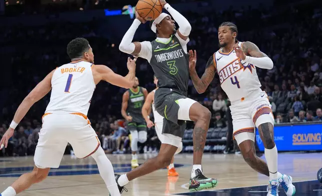 明尼蘇達木狼前鋒積頓麥丹尼爾斯（Jaden McDaniels）進攻，鳳凰城太陽後衛迪雲布加（Devin Booker）（1號）及謝倫格連（Jalen Green）（4號）防守。AP圖片