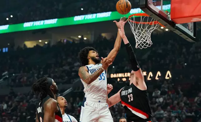 2026年3月27日周五，俄勒岡州波特蘭，NBA籃球賽上半場，達拉斯獨行俠前鋒馬文·巴格利三世（Marvin Bagley III）在波特蘭拓荒者中鋒多諾萬·克林根（Donovan Clingan）防守下投籃。（美聯社圖片/Jenny Kane） AP圖片