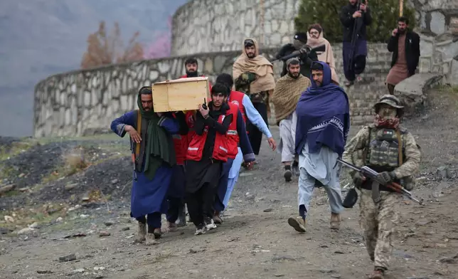 2026年3月18日周三，在阿富汗喀布爾，塔利班安全人員看守著運送周一空襲毒品康復醫院受害者遺體的人們，準備進行安葬。(美聯社圖片/Siddiqullah Alizai) AP圖片