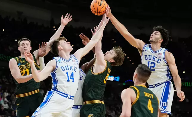2026年3月19日周四，在南卡羅來納州格林維爾（Greenville, S.C.）舉行的NCAA大學籃球錦標賽（NCAA college basketball tournament）首輪上半場，杜克隊的卡梅倫布澤（Cameron Boozer）（12號）和尼古拉斯卡梅尼亞（Nikolas Khamenia）（14號）與錫耶納隊的萊利馬爾維（Riley Mulvey）（55號）、布倫丹科伊爾（Brendan Coyle）（21號）和加文多蒂（Gavin Doty）（4號）爭奪籃球。(美聯社圖片/Brynn Anderson) AP圖片