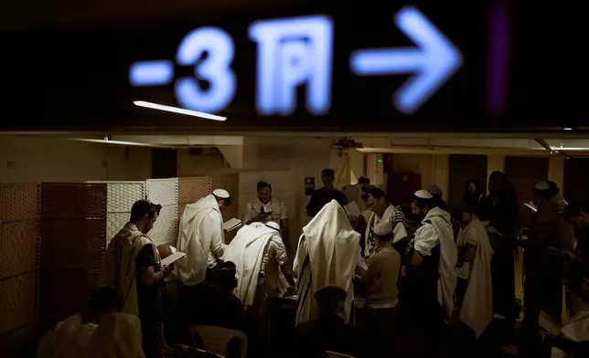 2026年3月3日周二，以色列特拉維夫（Tel Aviv）一個地下停車場內，身披祈禱披肩的猶太男子正在祈禱，該處被用作防範伊朗（Iran）可能導彈襲擊的避難所。(美聯社圖片/Oded Balilty) AP圖片