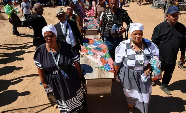 南非政府通訊及資訊服務處提供的照片顯示，2026年3月23日周一，在南非斯泰因科普夫（Steinkopf），家人和社區成員在重新安葬數十具非洲人遺骸的儀式上抬著棺木。這些遺骸早年被挖掘並運往歐洲作科學研究。(賈魯斯·穆特爾/南非政府通訊及資訊服務處 via 美聯社) AP圖片