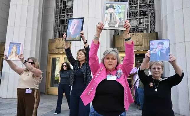 洛里·肖特（右二）於2026年3月25日周三，在洛杉磯高等法院一宗關於社交媒體平台是否故意使兒童上癮並造成傷害的標誌性審訊裁決後，與其他人一同舉起她女兒安娜莉·肖特的照片。（美聯社圖片/威廉·梁） AP圖片