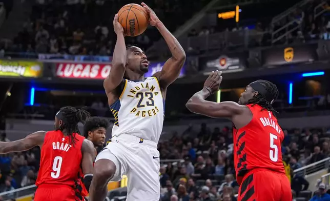 印第安納溜馬後衛尼斯密夫（Aaron Nesmith）在波特蘭拓荒者後衛賀利迪（Jrue Holiday）面前投籃。AP圖片